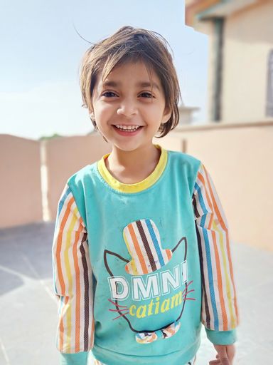 A happy South Asian female kid standing on the balcony