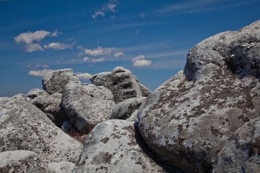 A closeup shot of several stones on top of each other under a blue sky