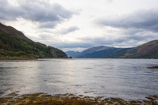 A stunning rocky beach and highlands at Elgol on the Isle of Skye under a cloudy sunset sky, Scotland