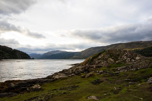 A stunning rocky beach and highlands at Elgol on the Isle of Skye under a cloudy sunset sky, Scotland