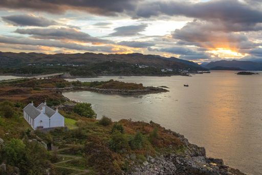 A stunning rocky beach and highlands at Elgol on the Isle of Skye under a cloudy sunset sky, Scotland