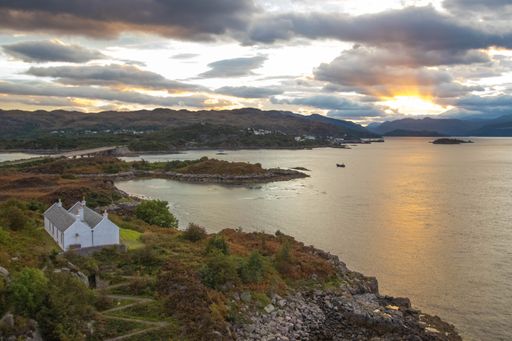 A stunning rocky beach and highlands at Elgol on the Isle of Skye under a cloudy sunset sky, Scotland