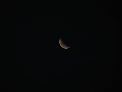 The moon in its last quarter phase with the dark night sky in the background
