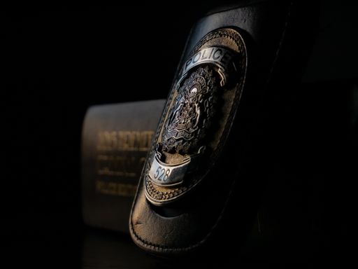 A close-up shot of a police badge leaning against the Criminal Code document