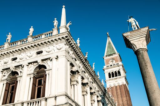A low angle shot of a beautiful and old building under the blue sky captured in Saint Marks Square, Venice, Italy