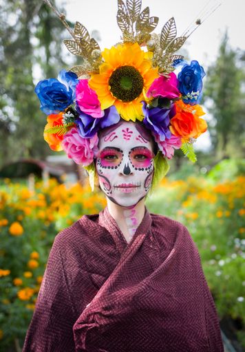 A vertical portrait of a female in La Calavera Catrina make up  on the day of the dead, Mexico
