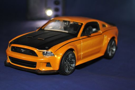 A closeup shot of a toy car on a blue background