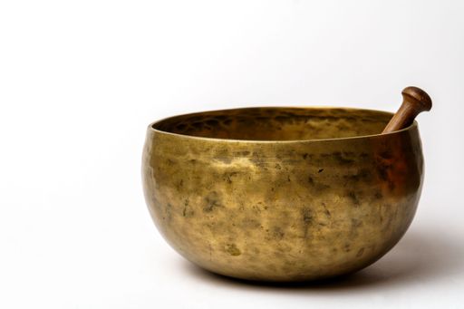 Tibetan singing bowl with wooden mallet resting on rim, creating a calming atmosphere for meditation and mindfulness practices