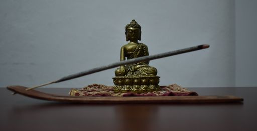 A panoramic closeup shot of a statue of Buddha on a wooden table