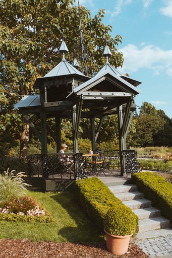 A vertical shot of a gazebo in the beautiful green park under a clear sky
