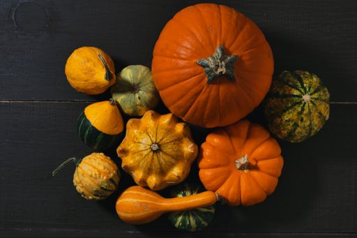 An overhead sho of different kinds of harvested pumpkins on wooden surface - Autumn still life