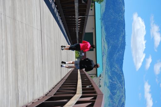 A sporty couple walking through the wooden pier or bridge towards the sea in summer