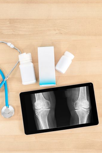 A vertical closeup of the medical equipment on the wooden table. Top view. Workplace of a doctor.