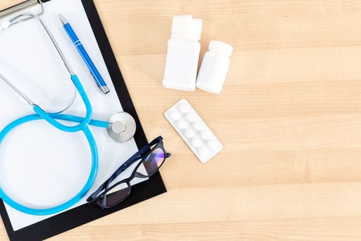 A closeup of the medical equipment on the wooden table. Top view. Workplace of a doctor.