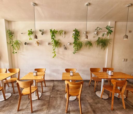 An interior of a small restaurant with wooden chairs and tables