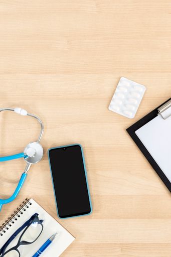 A closeup of the medical equipment on the wooden table. Top view. Workplace of a doctor.