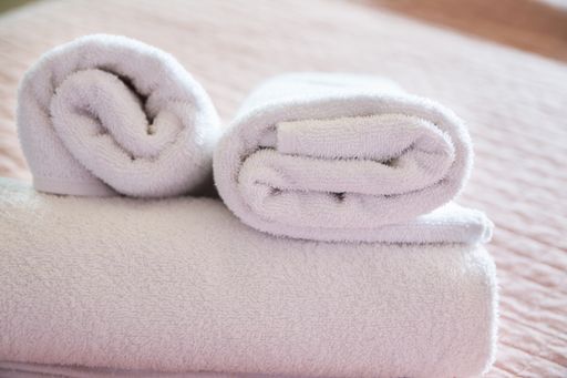 The rolled white towels on spa bed- body care concept
