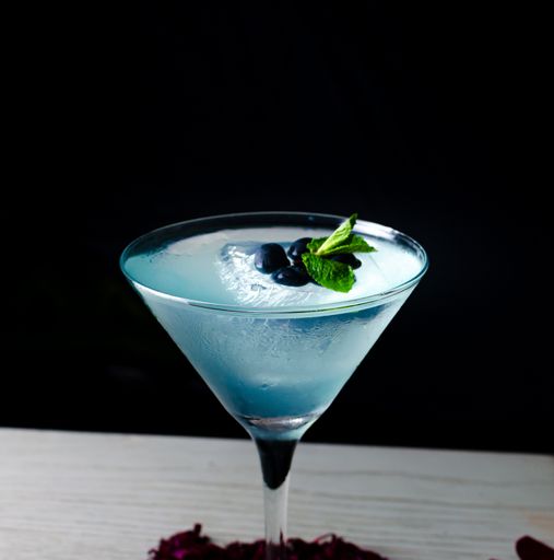 A closeup shot of a blue alcoholic cocktail on a dark background