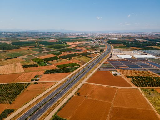 The aerial view of the road passing between fields. Valencia, Spain.