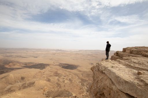A person walking on the rock in the desert