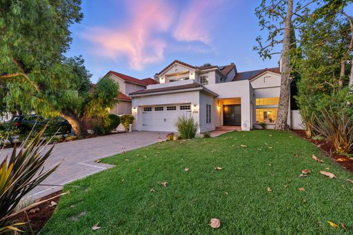 Enchanting two-story traditional with gated curb appeal, a private pool, spa, turf lawn, and cozy string-lit outdoor entertaining area.