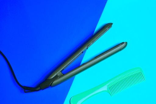 A top view of the hair straightener with the comb on the colorful surface