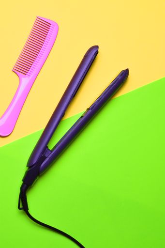 A top view of the hair straightener with the comb on the colorful surface
