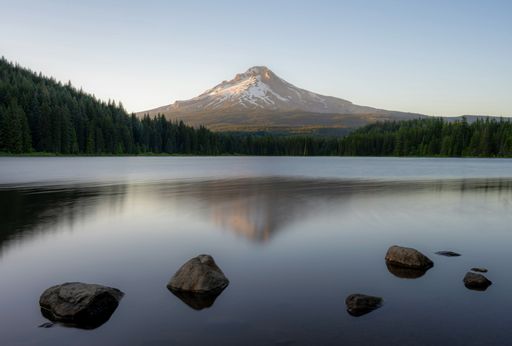 Scenic view of Mount Hood reflecting in Trillium Lake during a calm evening with clear skies and surrounding forest.