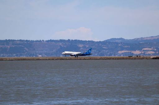 Alaska Horizon Embraer E175 in "Honoring Those Who Serve" livery landing at SFO, passing by a wind sock, coming in from Boise