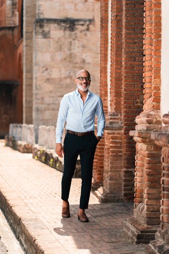 A vertical shot of a handsome stylish Hispanic male posing on the street