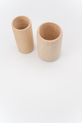 cylindrical pen holder made of solid wood on a white surface with text space
