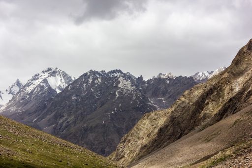 Beautiful landscape of the snow capped Himalayan mountains of the Zanskar range with an overcast sky on a wilderness trek in Himachal Pradesh, India.
