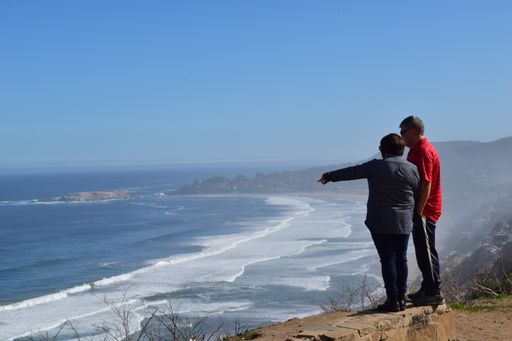 A couple standing at the beach admiring the wonderful view of the ocean