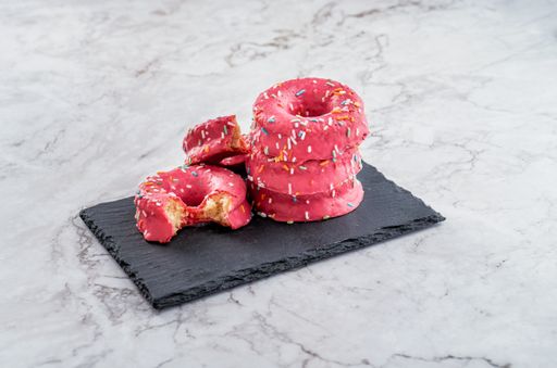 A closeup shot of delicious donuts with sprinkles on the table