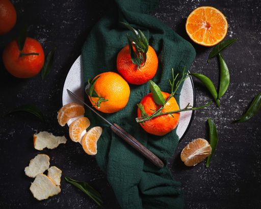 A top view of fresh mandarins on a dark table