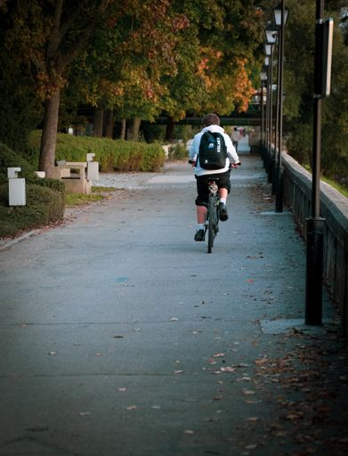 A vertical shot of random male cycling in the park