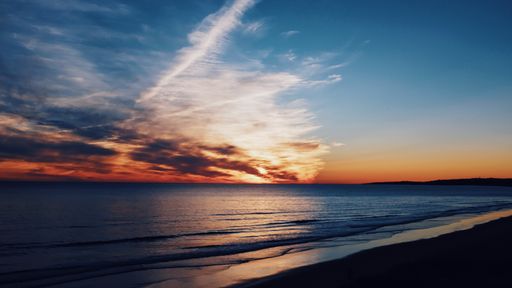 A beautiful shot of the coastline and the sea with breathtaking clouds in the sky at dawn