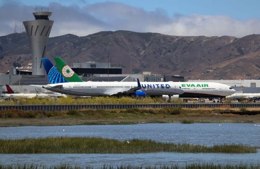 United Airlines Boeing 757-300 on runway with EVA Boeing 777 taxiing at San Francisco airport