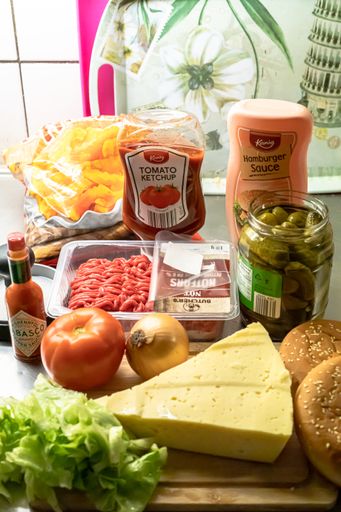 A vertical shot of the foods that make up a hamburger