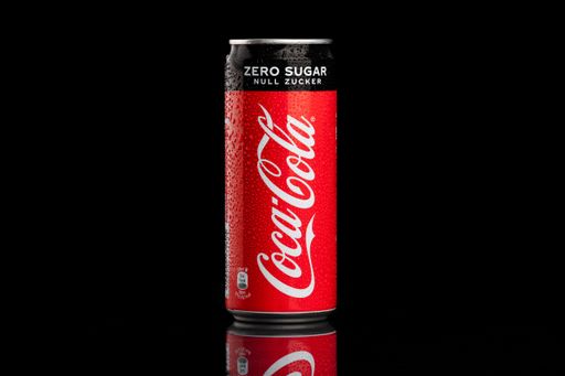 A wet aluminum cocal cola zero can isolated on a black background
