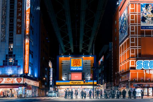 A famous crossing in Akihabara Tokyo with a lot of people and a night cityscape in the background, Japan