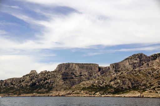 A scenic view of rocky cliffs surrounded by the ocean in Massif des Calanques, France