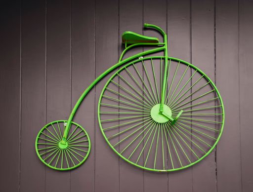 A penny-farthing bicycle hanging on a wall