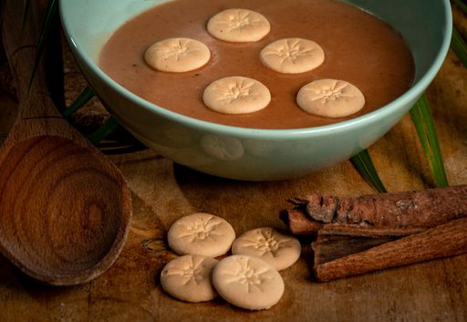 An overhead shot of some cookies which are put in the cream soup, wooden spoon and cinnamon