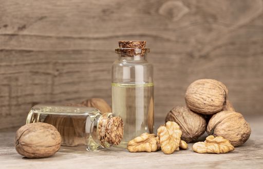 Walnut oil still life. Glass bottle of nut oil on rustic wooden table