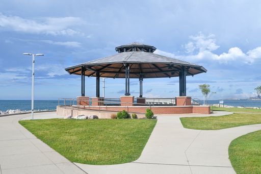 A gazebo near a shore under a cloudy sky
