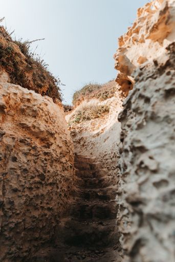A vertical shot of stairs between rocks on a sunny day