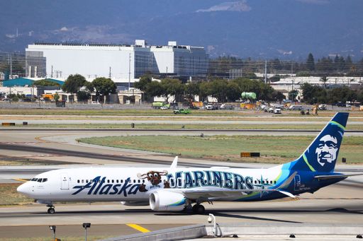 Alaska Airlines in Seattle Mariners livery taxiing to the gates at San Jose International Airport with the Santa Cruz mountains in the background