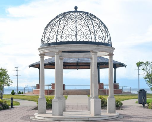 A gazebo near a shore under a cloudy sky
