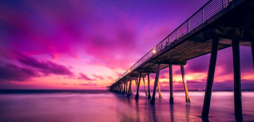 A panoramic shot of the Hermosa Beach Pier on the ocean with long exposure during a beautiful sunset in California